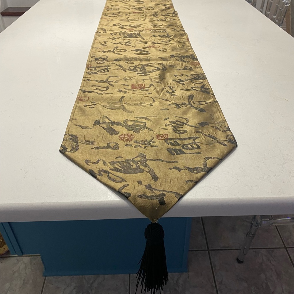 Table runner: 88” gold w/ black abstract markings & 6” black tassel on each end